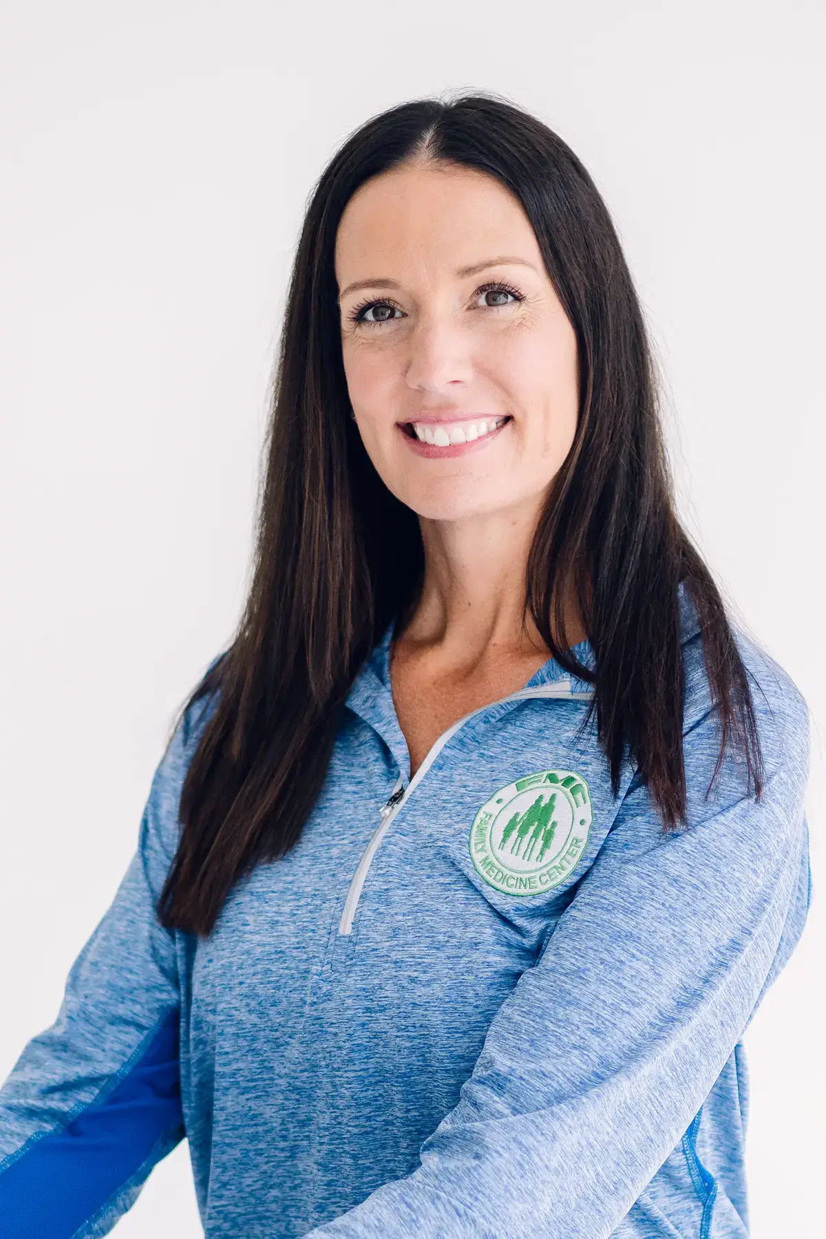 Smiling woman in blue zip-up sweater.